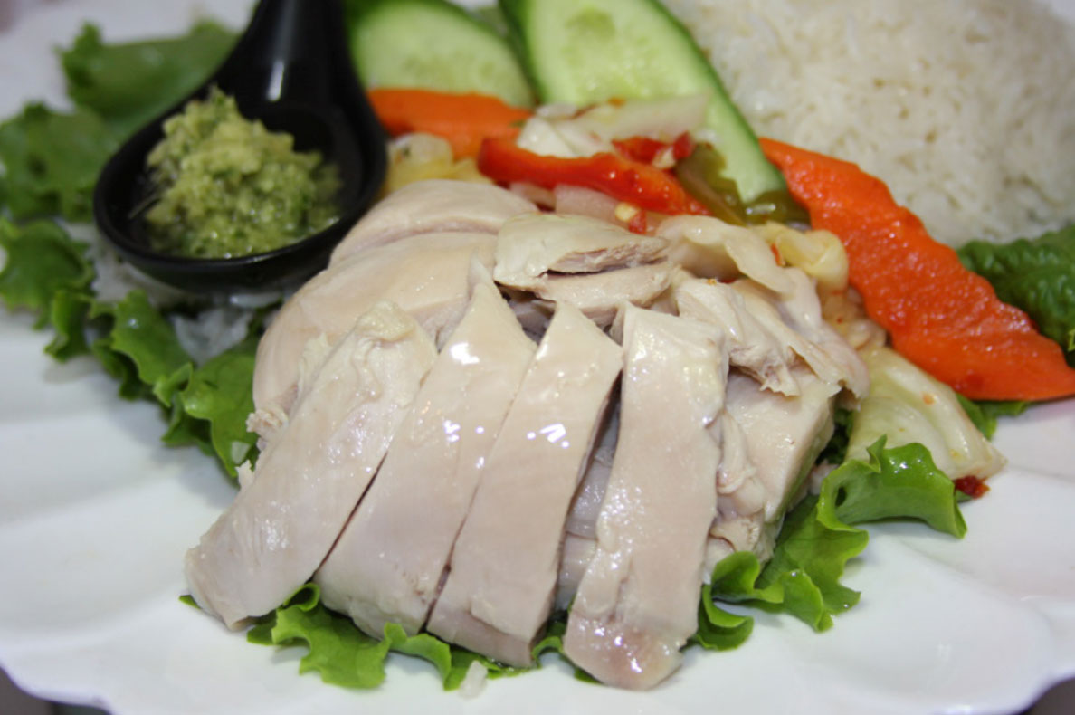 Hainan chicken rice: poached chicken, pickled vegetables, ginger rice and sauces